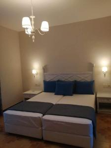 a bedroom with a large bed with blue pillows at Dionisia apartments 8 in Kos
