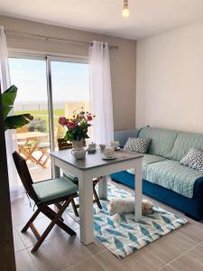 a living room with a table and a couch at Studio-terrasse 3* bord de mer Châtelaillon plage in Châtelaillon-Plage