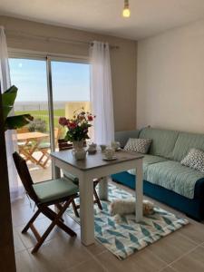 - un salon avec une table et un canapé dans l'établissement Studio-terrasse 3* bord de mer Châtelaillon plage, à Châtelaillon-Plage