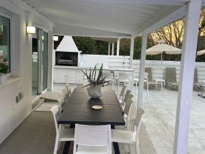 een patio met een tafel en stoelen en een keuken bij Konnos Hight Villa in Protaras