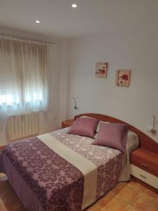 a bedroom with a large bed with purple pillows at Apartamento Torre Sancho in Valderrobres