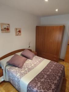 1 dormitorio con 1 cama y armario de madera en Apartamento Torre Sancho, en Valderrobres