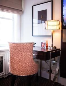 a desk with a chair next to a desk with a lamp at The Lexington Hotel, Autograph Collection in New York