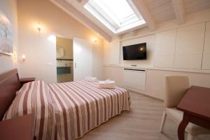 a bedroom with a bed and a television in it at Villino Micol camere a due passi dal mare in Marina di Carrara