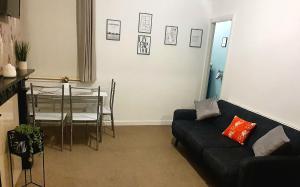 a living room with a couch and a table at Rooms Anfield- 5 mins from LFC in Liverpool