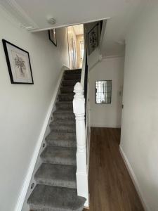 a staircase in a home with white walls and wooden floors at Watford Road House Liverpool in Liverpool
