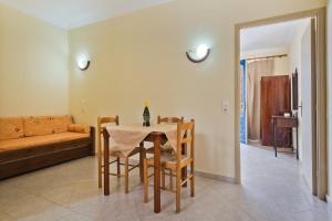 a dining room with a table and chairs and a couch at Sea Melody in Lefkos Karpathou