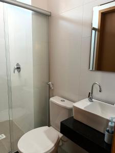 a bathroom with a toilet and a sink and a shower at Apartamento com piscina no Condominio Maraca2 in Ipojuca