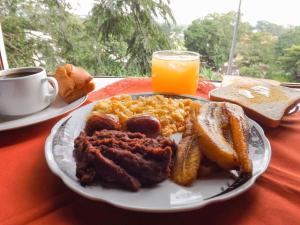 un piatto di prodotti per la colazione con carne, uova e pane tostato di Real Guanacaste a San Pedro Sula