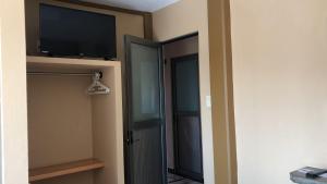 a room with a tv and a door with a television at Hotel Catala in Tecolutla