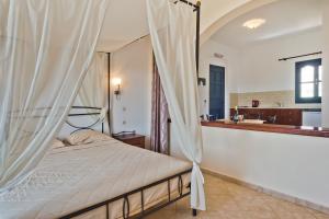 a bedroom with a canopy bed and a bathroom at Sea Melody in Lefkos Karpathou