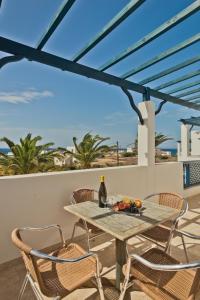 a table and chairs on a patio with a view of the ocean at Sea Melody in Lefkos Karpathou