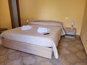 1 dormitorio con 1 cama con 2 toallas en ALLOGGIO TURISTICO MAGNIFICO ALESSANDRO VALLE BERNARDO 04025 LENOLA LT CIR 19063 nei pressi di 04022 FONDI LT, en Lenola