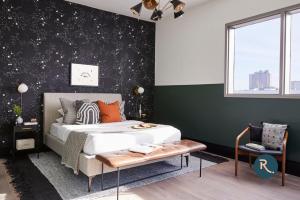 - une chambre avec un lit et un mur noir avec des étoiles dans l'établissement Roami at The Brandywine, à La Nouvelle-Orléans