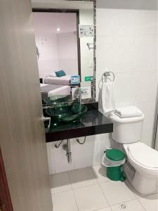 y baño con lavabo, aseo y espejo. en Casa Hotel Quinta Real, en Bogotá