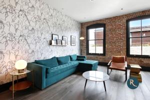 a living room with a blue couch and a brick wall at Roami at The Brandywine in New Orleans