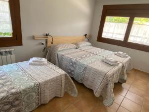 1 dormitorio con 2 camas y ventana en Allotjament Cal Bru en Sant Llorenc de Morunys