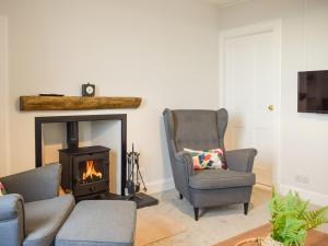 a living room with two chairs and a fireplace at Cromwell Cottage in Burntisland
