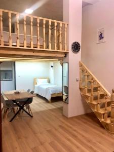 a loft apartment with a bed and a staircase at Guest House Dashi in Gjirokastër