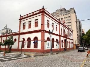 um edifício vermelho e branco na esquina de uma rua em Flat em frente ao Cais Embarcadeiro em Porto Alegre