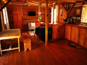 a kitchen and living room of a log cabin at Mango Bottom Jackson Trace in Castara