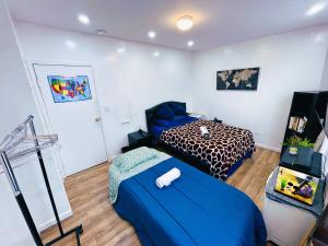 a bedroom with two beds and a blue blanket at Big Bedroom Best Location ! - Free Parking and first floor in Queens