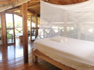 a bedroom with a bed with a mosquito net at Mango Bottom Jackson Trace in Castara