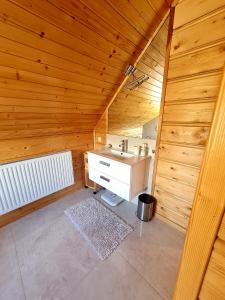 Habitación de madera con baño con lavabo. en Gorczańska Chata z tarasem widokowym, en Poręba Wielka