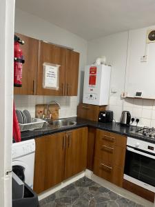 a kitchen with a sink and a stove top oven at 03 Bedroom Apartment-Self Check in in London +19 photos