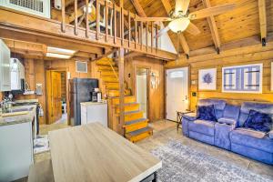 オキーチョビーにあるOkeechobee Cabin in Waterfront Community with Dock!の青いソファとキッチンのあるリビングルーム