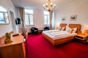 ザンクト・ゴアーにあるHotel zum Goldenen Löwenのベッドとデスクが備わるホテルルームと
