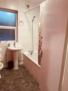 a bathroom with a sink and a tub and a toilet at 03 Bedroom Apartment-Self Check in in London