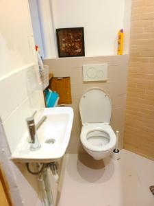 uma casa de banho com um WC e um lavatório em Home Cosy ARENA Porte de la Chapelle em Paris