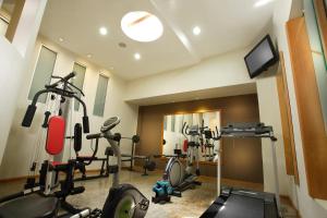 a gym with several tread machines and a television at El Dorado Hotel in Cuenca