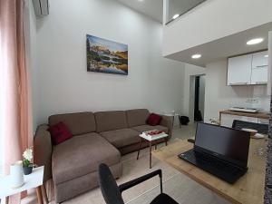 a living room with a couch and a laptop on a table at Korzo Apartment in Bijelo Polje
