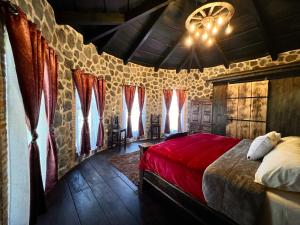 a bedroom with a red bed in a room with windows at Villas Gasconia in Antigua Guatemala