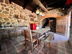 a kitchen with a wooden table and a stone wall at Villas Gasconia in Antigua Guatemala