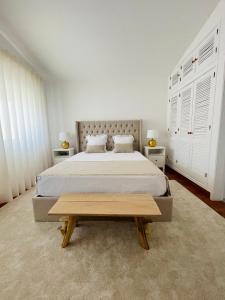 a bedroom with a large bed and a wooden table at Villa Serro das Vinhas in Portimão