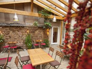 a patio with tables and chairs and a stone wall at Hôtel le Grillon in Strasbourg +49 photos