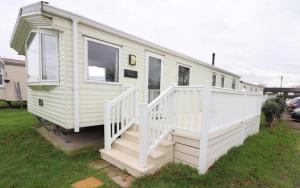 a white mobile home with a white staircase at 3 bed caravan Norfolk near the coast in Belton