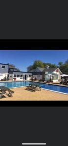 a picture of a swimming pool with a picnic table at 3 bed caravan Norfolk near the coast in Belton