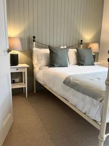 a bedroom with a bed with blue and white pillows at Wellington Cottage in Ilkley