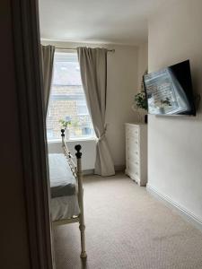 a room with a window and a dresser and a bed at Wellington Cottage in Ilkley