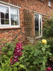 a brick house with flowers in front of it at The Guest Suite, Buttsfield Lane. in East Hoathly