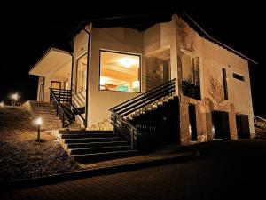 a building with stairs in front of it at night at Villa & SPA 4Temporadas - Plaiul Foii in Zărneşti