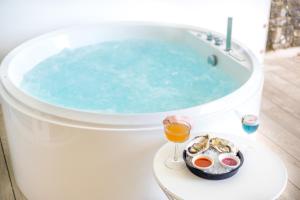 a bath tub with a plate of food and a glass of wine at The Nici in Bournemouth