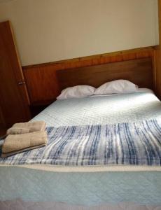 Una cama con dos toallas encima. en Cabaña Los Mañíos Salto del Laja, en Los Ángeles