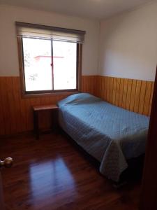 Habitación pequeña con cama y ventana en Cabaña Los Mañíos Salto del Laja, en Los Ángeles