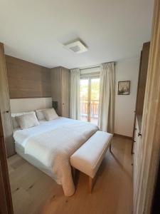 梅傑夫的住宿－Les Chamois D’Arbois, Mont D’Arbois, Megève，一间卧室设有一张大床和一个窗户。