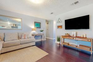 a living room with a couch and a flat screen tv at Bluebonnet Bungalow in Austin